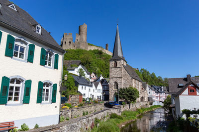 River elz with half-timbered houses and church in monreal, germany