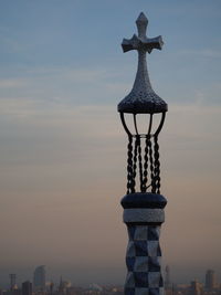 Sculpture of building against cloudy sky during sunset