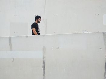 Young man standing against wall