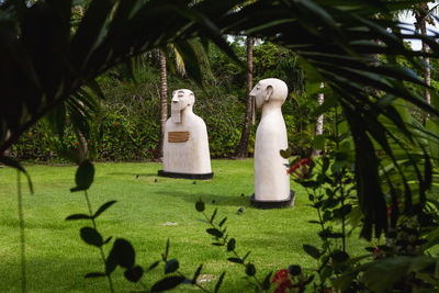 White sculpture by tree against plants