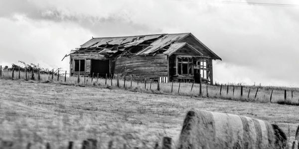 Old ruin on field against cloudy sky