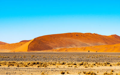 Scenic view of desert against clear blue sky