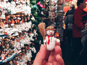 Cropped hand holding figurine at market