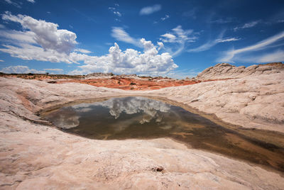 Scenic view of pond amidst rock formations against sky