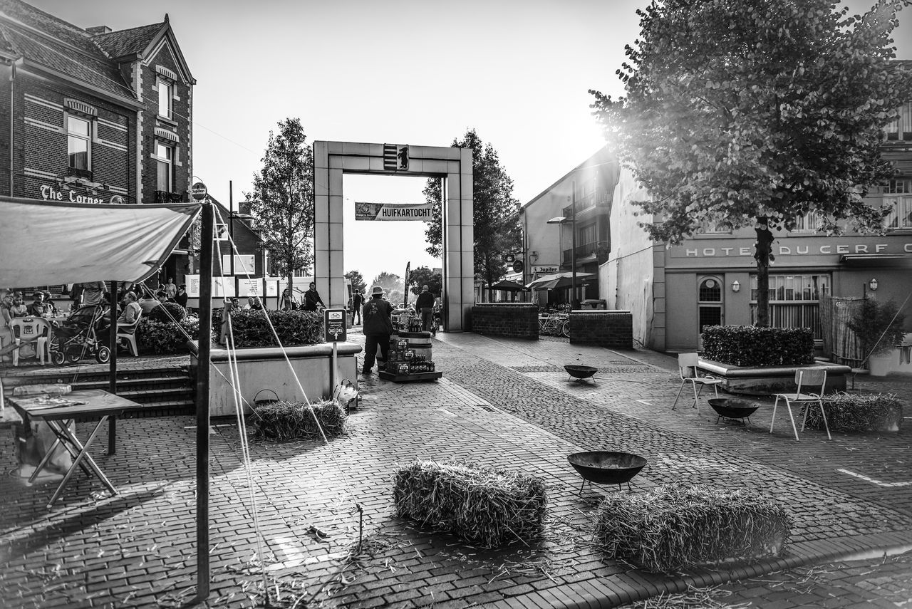 PEOPLE ON STREET AMIDST BUILDINGS AGAINST SKY