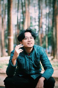 Young man sitting in forest