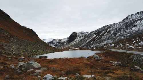 Scenic view of lake by mountains against sky