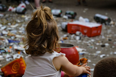 Close-up of girl and boy by garbage