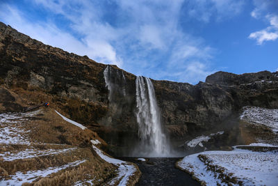 Scenic view of waterfall against sky