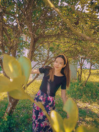 Portrait of smiling young woman against plants