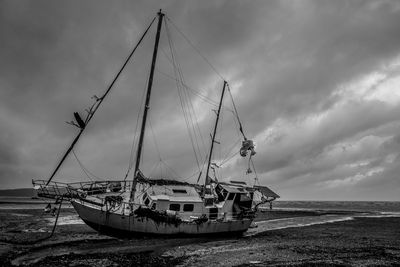 Shipwreck at beach against sky