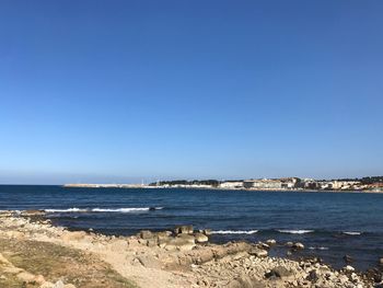 Scenic view of sea against clear blue sky