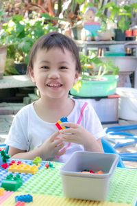 Cute asian girl, little toddler child playing creative colorful building blocks toy at home.