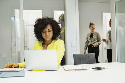 Woman using laptop in boardroom