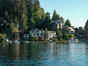 Buildings by river against sky