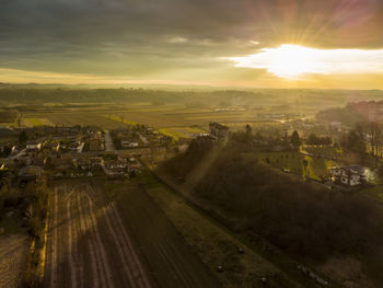 Aerial view of agricultural landscape against sky during sunset