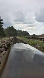 Surface level of road against cloudy sky