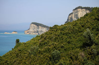 Scenic view of sea and mountains against sky