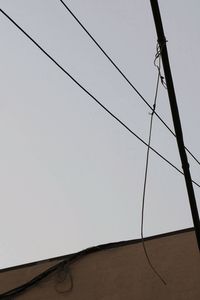 Low angle view of power lines against clear sky