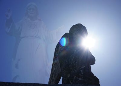 Low angle view of statue against blue sky