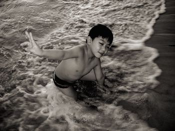 High angle view of boy playing on shore at beach