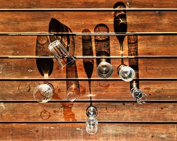 High angle view of drinking glasses on wooden table