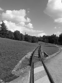 Railroad tracks by trees against sky