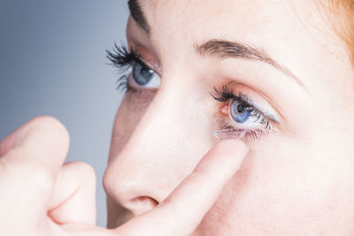 Close-up of woman applying contact lens