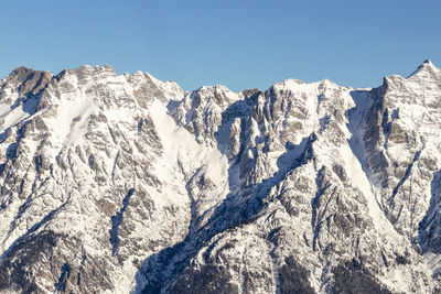 Panoramic view of snowcapped mountains against clear blue sky
