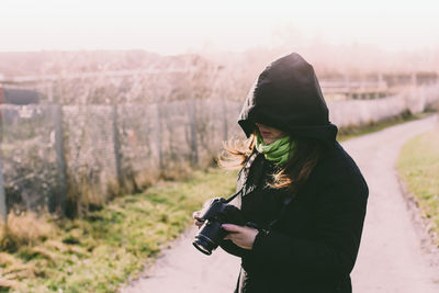 Woman photographing on snow covered landscape