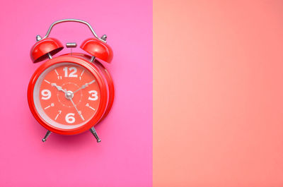 Close-up of clock on pink background