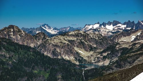 Scenic view of snow covered mountains against blue sky