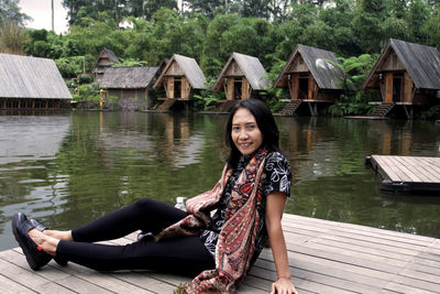 Portrait of woman sitting by lake