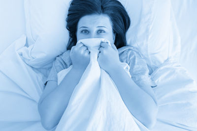 Portrait of young woman sleeping on bed at home