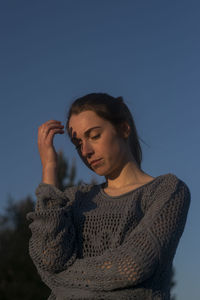 Young woman looking at camera against sky