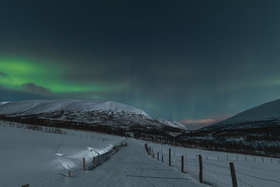 Scenic view of snowcapped mountains against sky at night