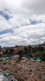 View of cityscape against cloudy sky