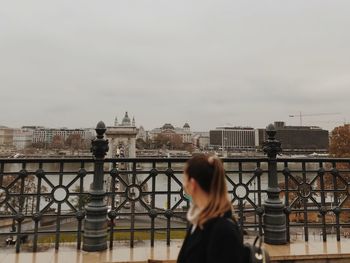 Side view of woman looking at cityscape