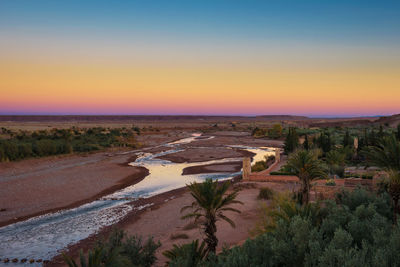 Scenic view of land against clear sky during sunset