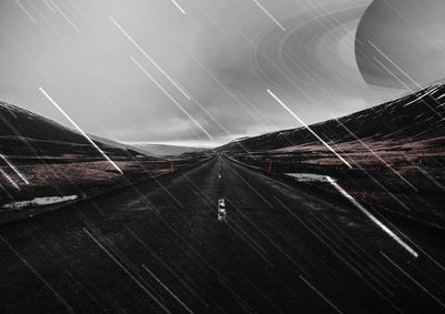 Low angle view of illuminated road against sky at night