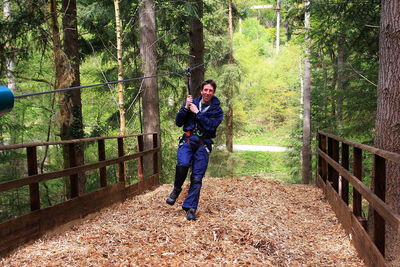 Mature man zip lining at forest