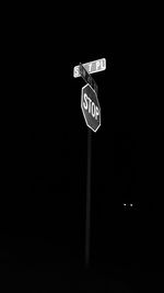 Close-up of road sign at night