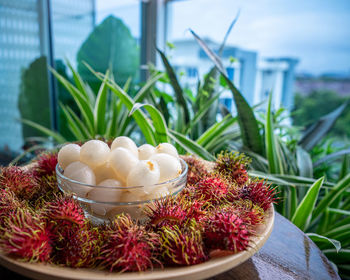 Rambutan, malaysian sweet delicious fruits in bowl and bamboo plate in the balcony garden.