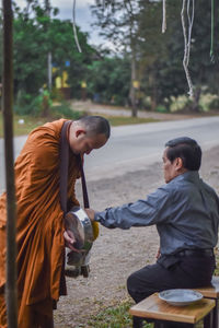 Man giving food to monk