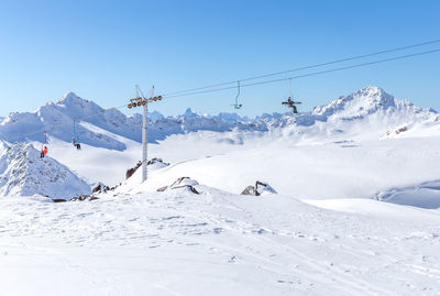 Scenic view of snow covered mountains against blue sky