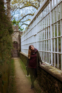 Full length of woman standing by retaining wall at botany