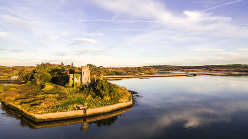 Castle by river against sky