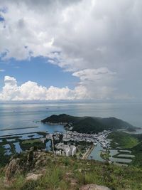Scenic view of sea by buildings against sky