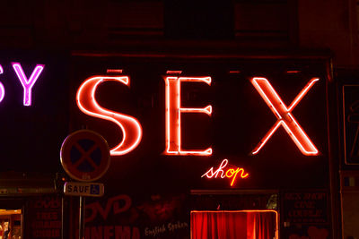 Low angle view of illuminated neon sign at night