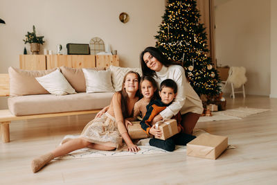 A large family celebrates holidays at home. mom with teens children in decorated living room